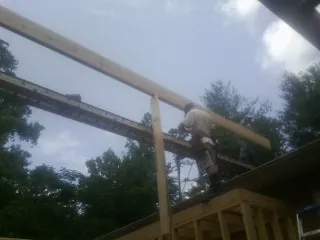 Carpenter setting a ridge beam over a new addition frame — Ice Dam Removal by Roofing Brothers in Rhododendron