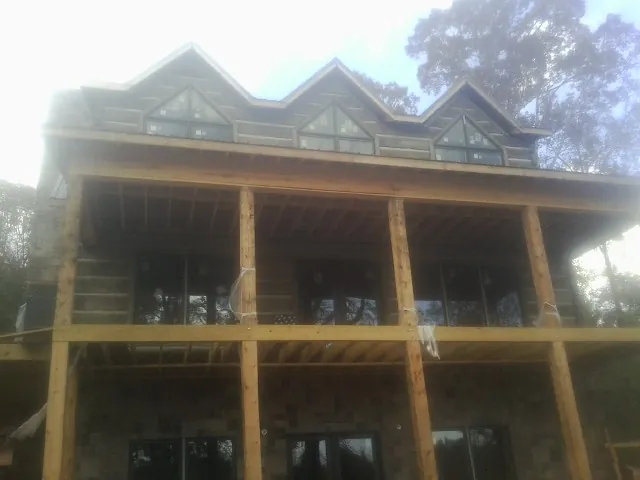 Dormers and porch framing on a large log home under construction — Roof Coating work by our crew in Rhododendron