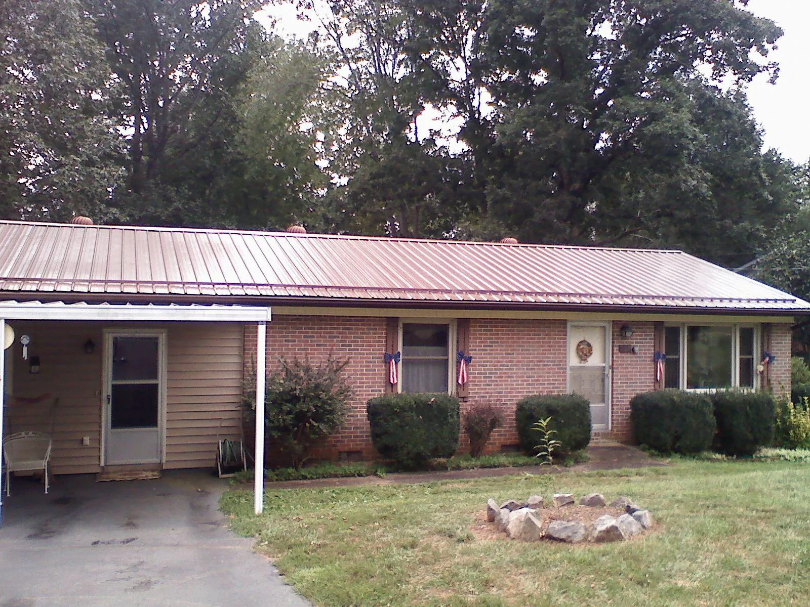 Bronze metal roof and carport on a brick ranch home — Roof Repair work by our crew in Rhododendron